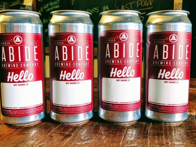 Four cans of Abide Brewing Company beer