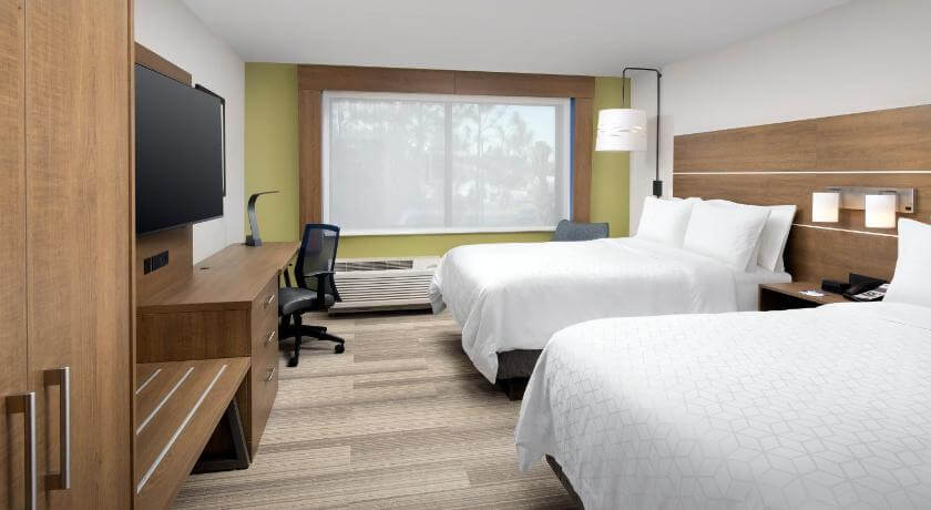 Two beds with fresh white linens in a guest room at the Holiday Inn Express in Newnan
