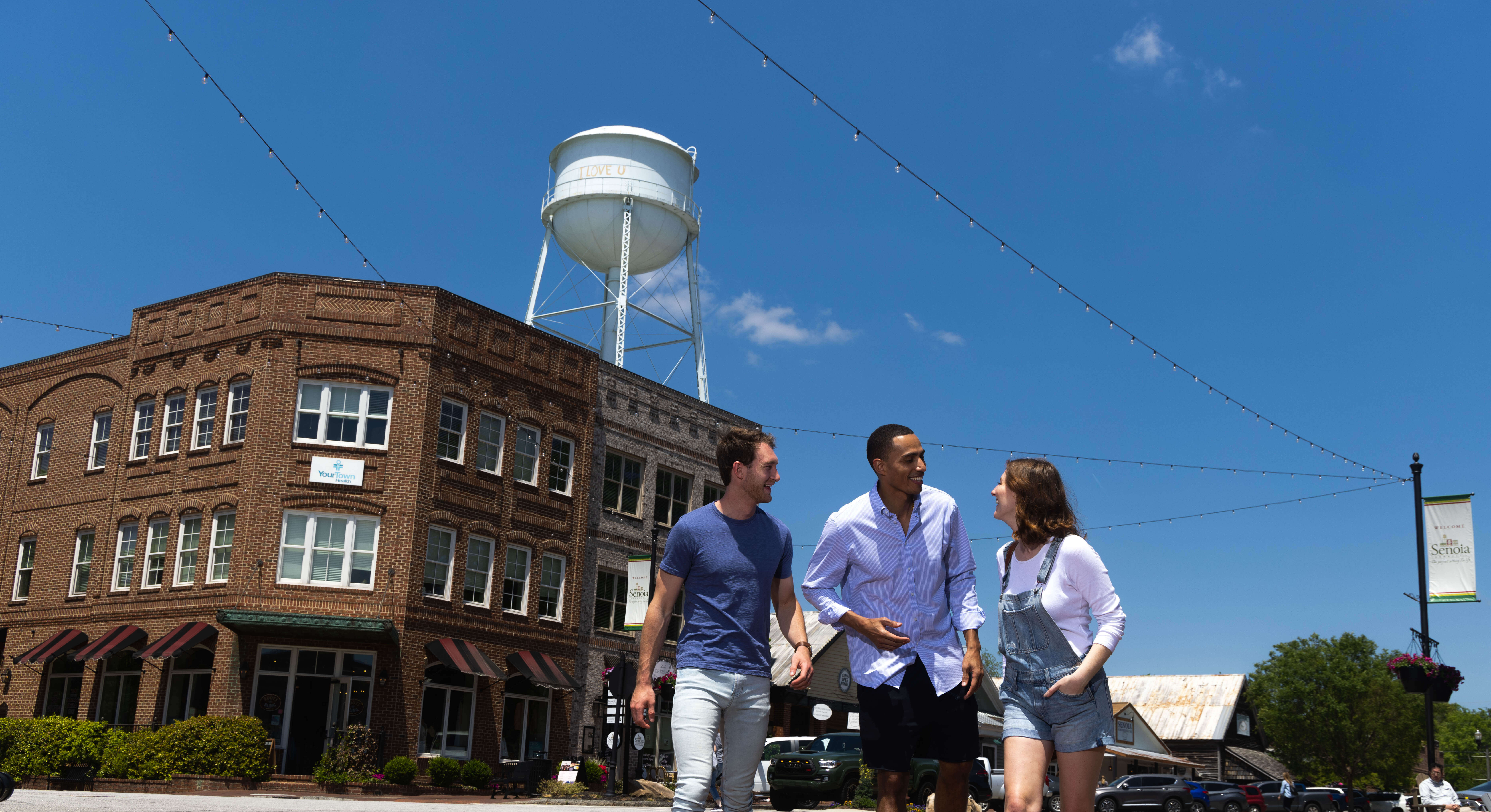 Three friends exploring downtown Senoia with famous watertower in background