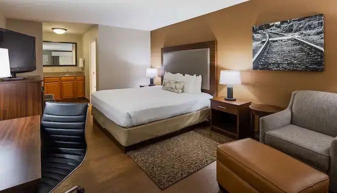 Clean and modern hotel room with bed, chair, desk, and TV at Best Western