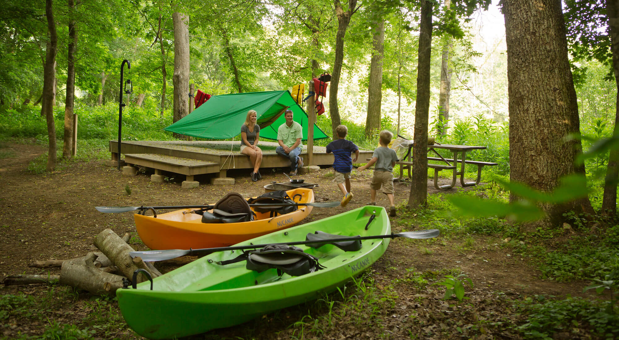 Family at a campsite with kayaks