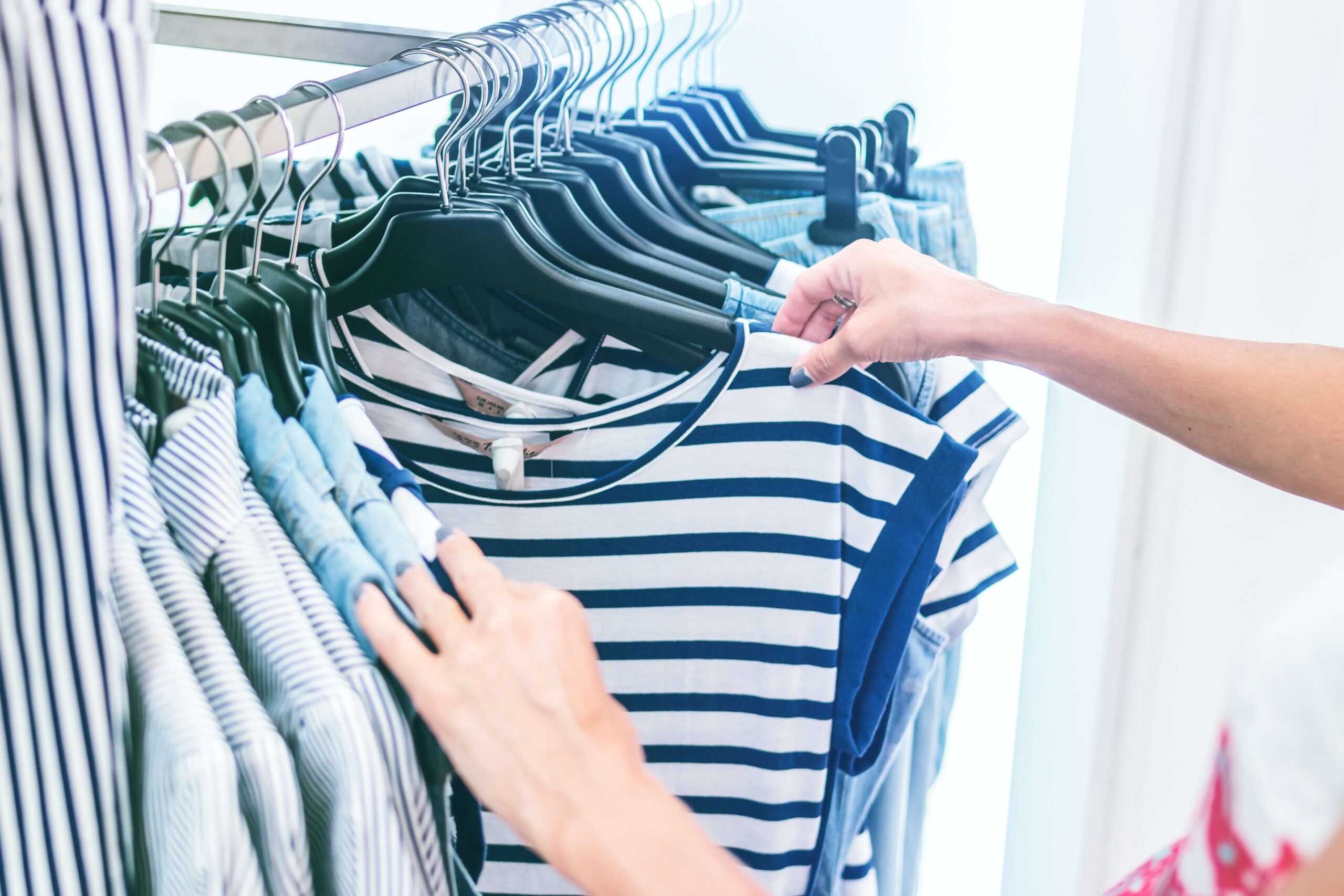 Woman searching through clothing rack at Holiday Boutique Crawl event