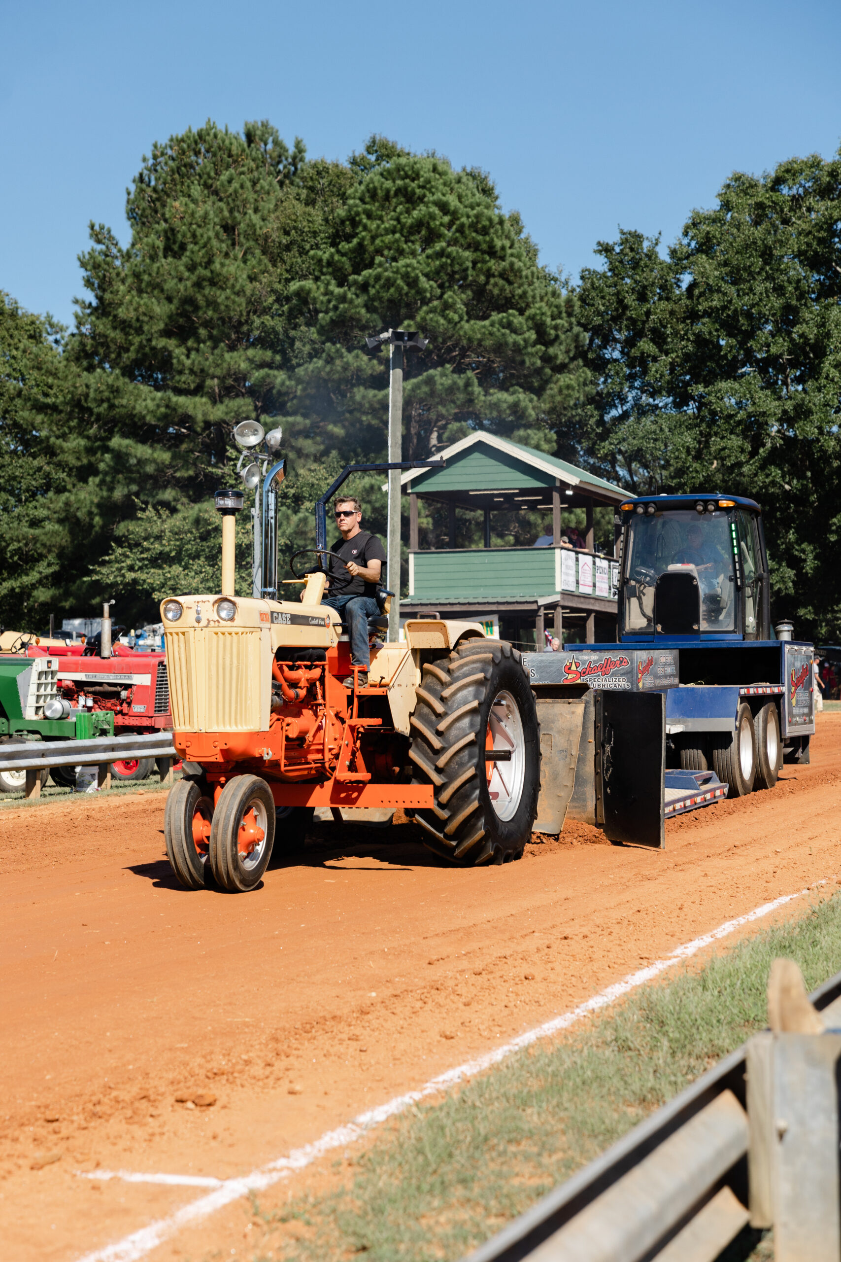 Man driving tractor while pulling weighted sled