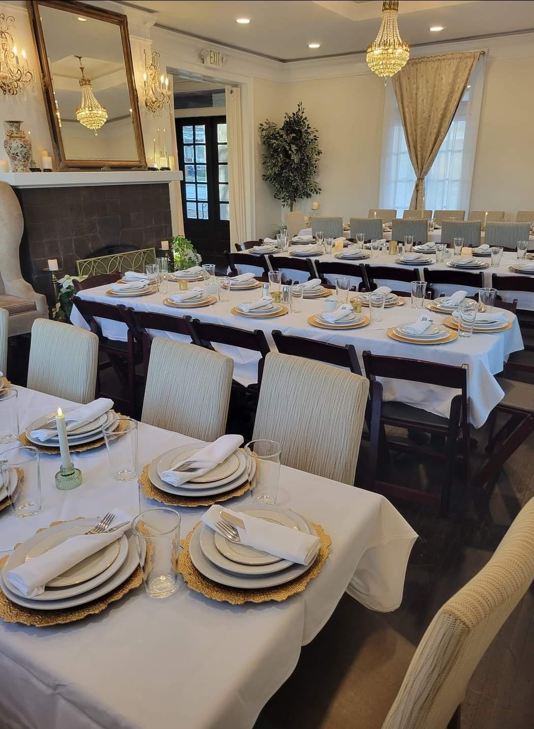 Tables set with white tablecloths and formal place settings