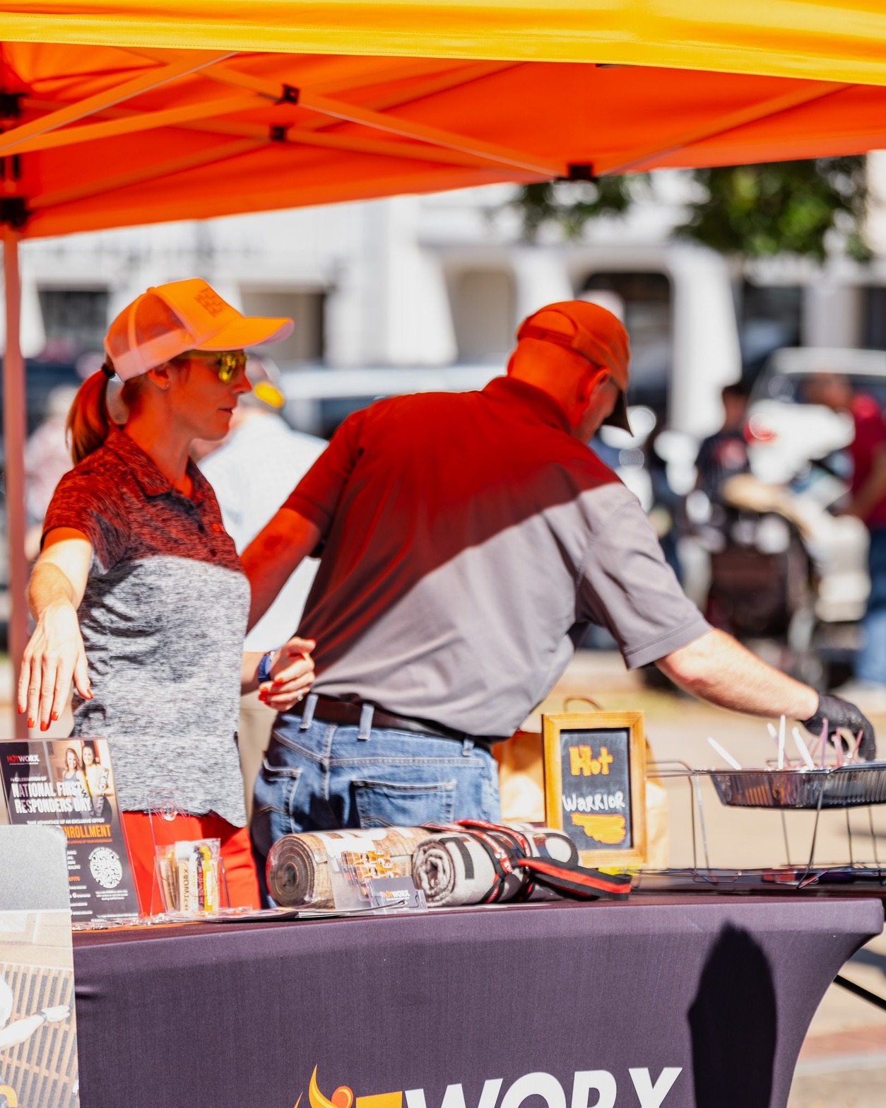 Girl and Guy running the Hot Worx Booth for the Chili cook off.