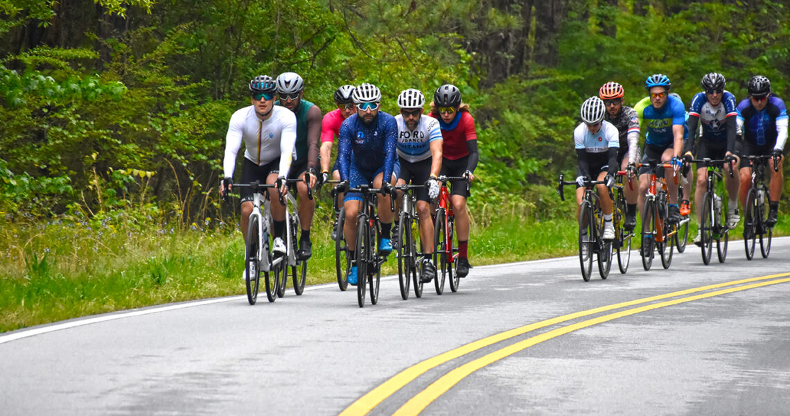 Group of cyclist racing down the street.