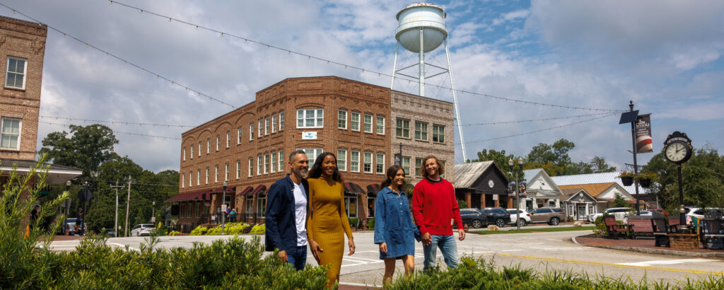 Two couples strolling down Mainstreet in Downtown Senoia