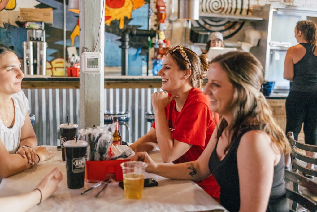 3 girls laughing at a table for lunch at Karvellas