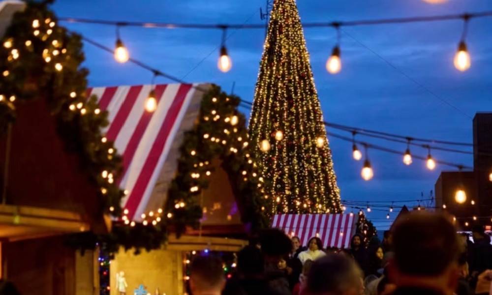 The Atlanta Christkindl Market, a traditional German-style Christmas village that features rows of wooden stalls, festive lights, and holiday decor.